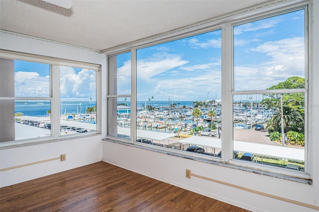 unfurnished sunroom featuring a water view