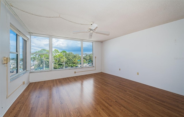 spare room featuring a textured ceiling, ceiling fan, and dark hardwood / wood-style floors