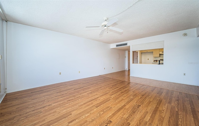 interior space featuring wood-type flooring, a textured ceiling, and ceiling fan