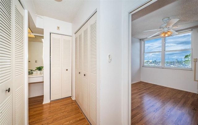 hallway with dark wood-type flooring and a textured ceiling