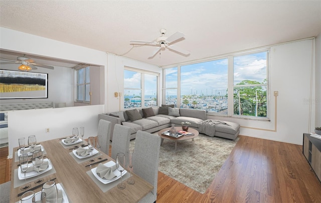 living room featuring a textured ceiling, ceiling fan, and hardwood / wood-style flooring