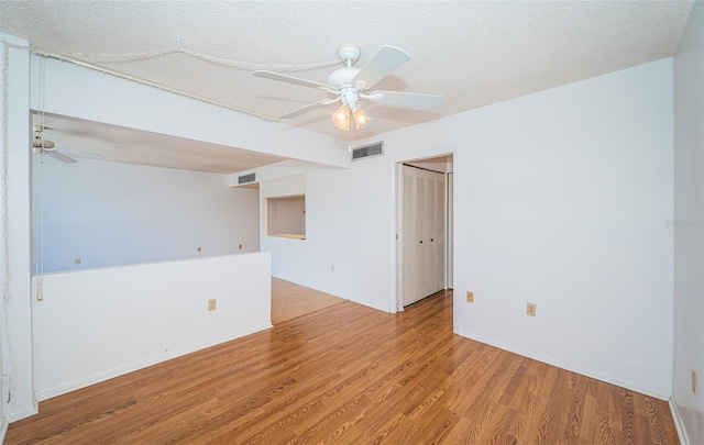 spare room with a textured ceiling, ceiling fan, and hardwood / wood-style floors