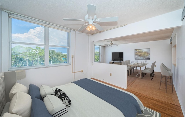 bedroom featuring a textured ceiling, ceiling fan, and wood-type flooring