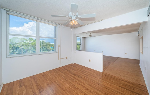 unfurnished room featuring a textured ceiling, ceiling fan, and hardwood / wood-style floors