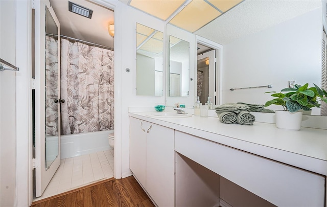 full bathroom featuring hardwood / wood-style floors, toilet, shower / bathtub combination with curtain, and vanity