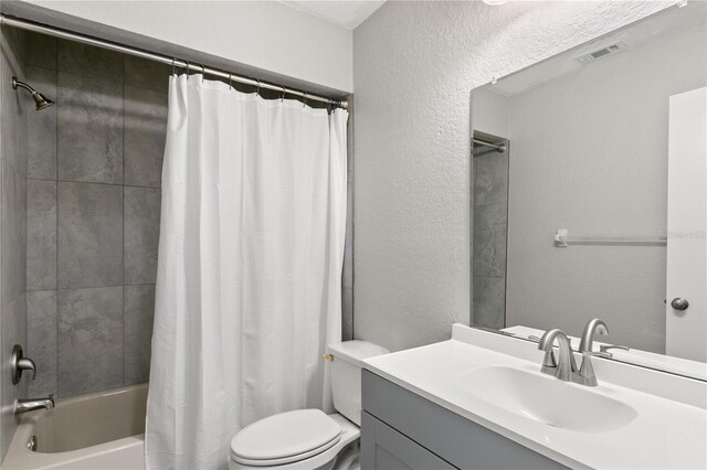 full bathroom featuring shower / bathtub combination with curtain, vanity, and toilet