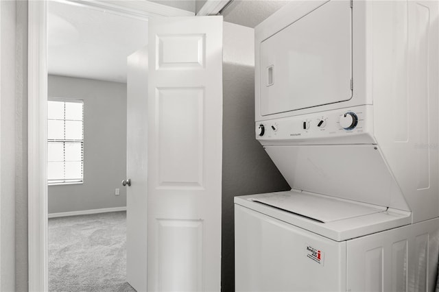 washroom featuring stacked washer and dryer and carpet flooring