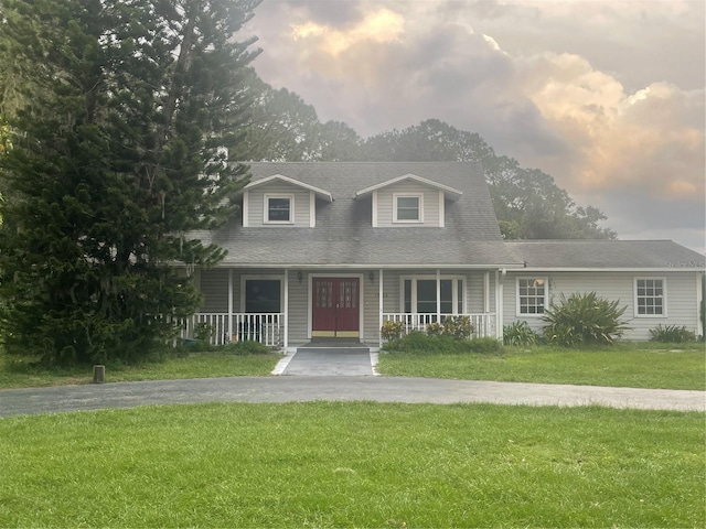 view of front of house with a porch and a lawn