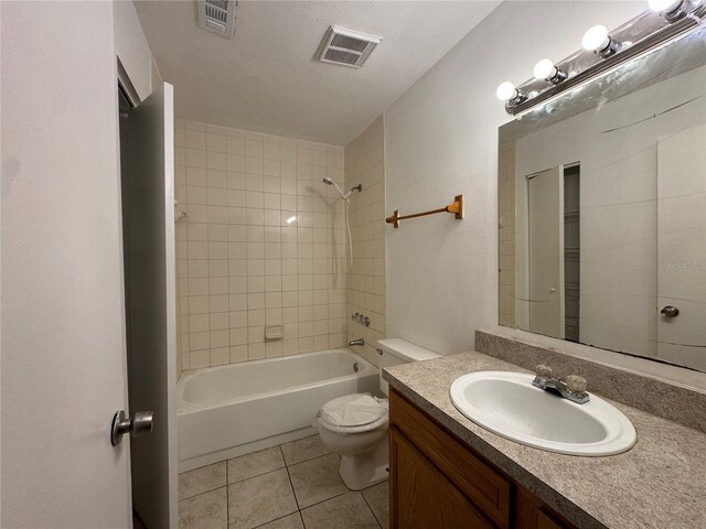 full bathroom with a textured ceiling, vanity, toilet, tiled shower / bath, and tile patterned floors