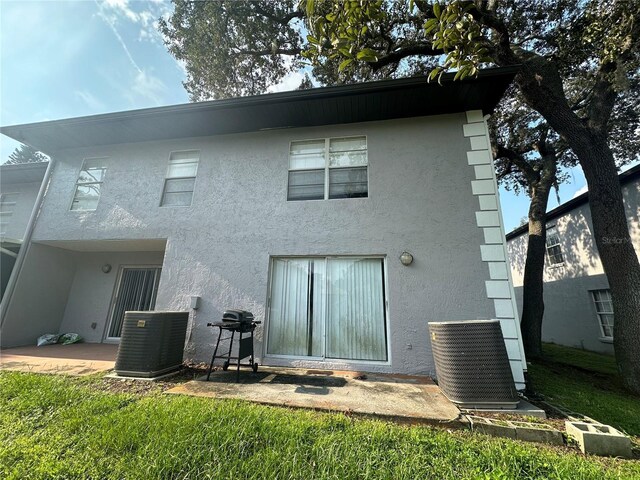 rear view of house featuring a yard and central AC unit