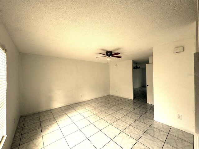 tiled spare room featuring a textured ceiling and ceiling fan