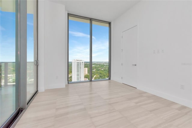 unfurnished room featuring plenty of natural light and floor to ceiling windows