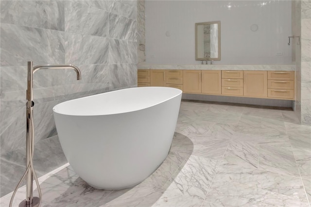 bathroom featuring tile walls, a bathing tub, and vanity