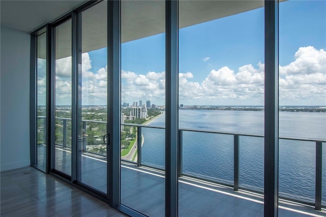 interior space with a wall of windows and a water view