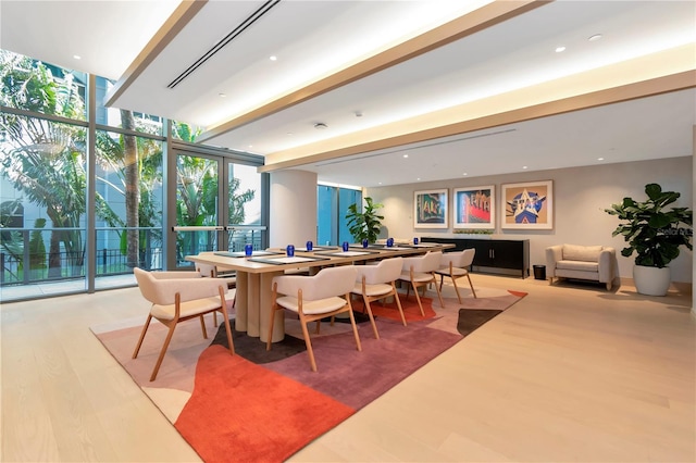 dining room with plenty of natural light, hardwood / wood-style floors, and a wall of windows