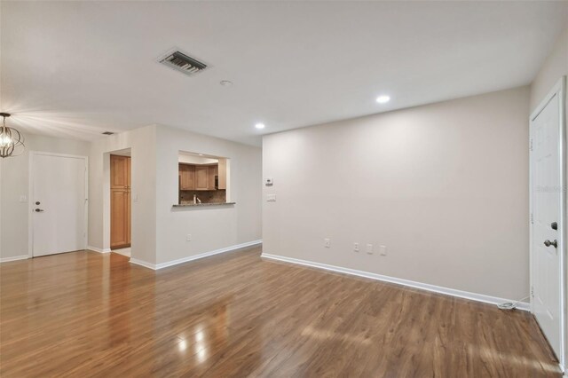 interior space with wood-type flooring and an inviting chandelier