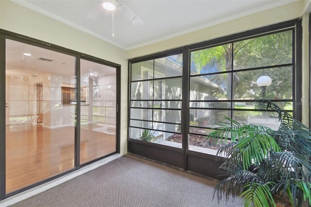 unfurnished sunroom featuring a healthy amount of sunlight and ceiling fan