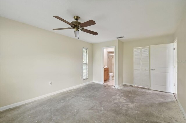 unfurnished bedroom featuring ensuite bath, ceiling fan, and a closet