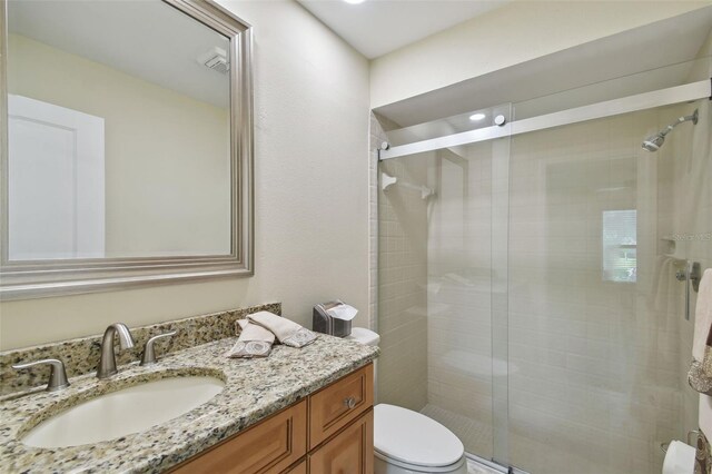 bathroom with vanity, toilet, and walk in shower