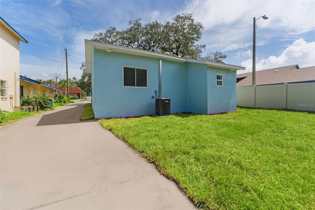 back of house featuring a yard and central AC unit