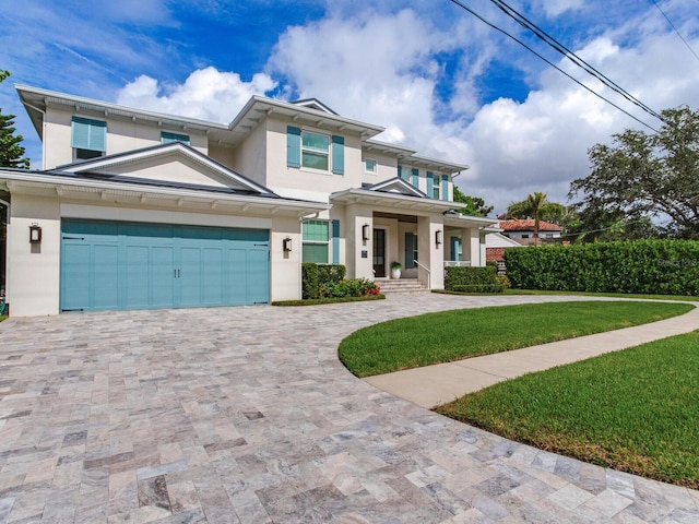 view of front of house featuring a front yard, a porch, and a garage