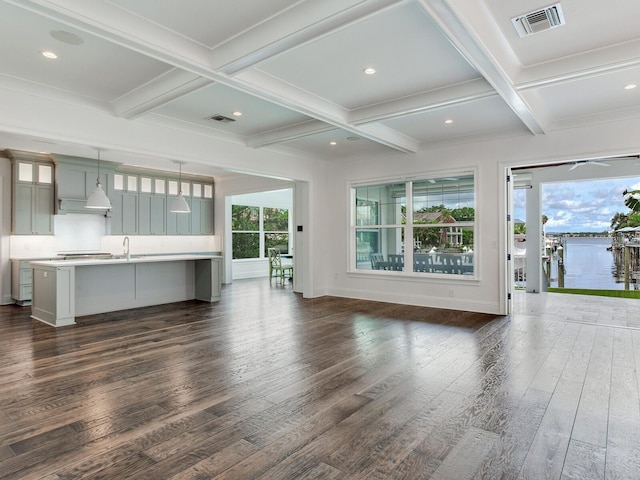 unfurnished living room featuring coffered ceiling, beamed ceiling, sink, and dark wood-type flooring