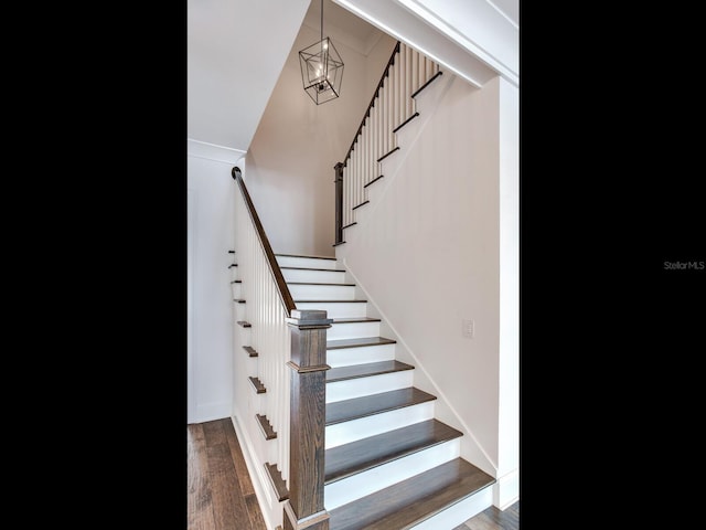 stairs featuring a chandelier and hardwood / wood-style flooring