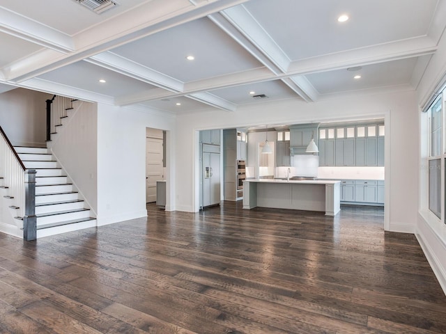 unfurnished living room with beamed ceiling, sink, ornamental molding, dark wood-type flooring, and coffered ceiling