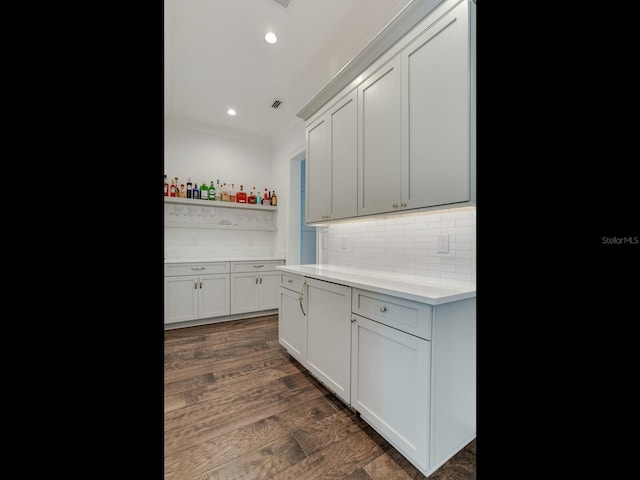 kitchen with ornamental molding, dark wood-type flooring, and tasteful backsplash