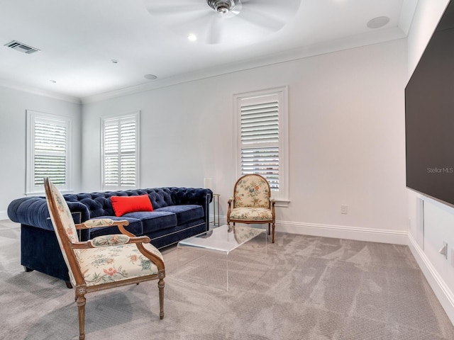 carpeted living room featuring ornamental molding and ceiling fan