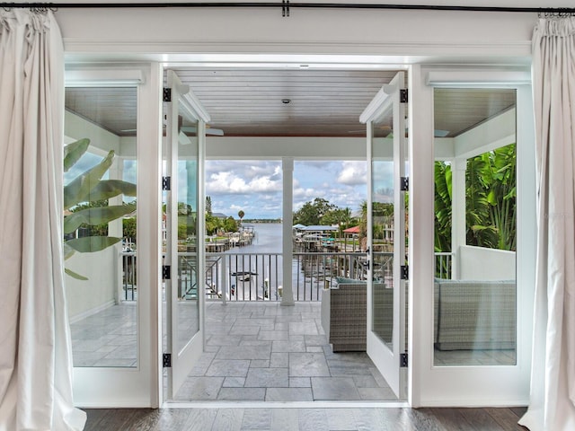 interior space with a water view, wooden ceiling, and a healthy amount of sunlight