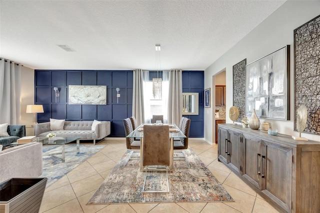 tiled dining area featuring a textured ceiling