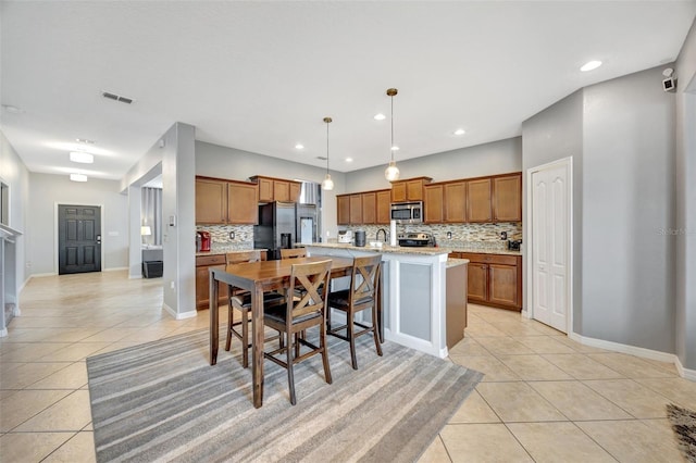 10820 Carloway Hills Dr, Wimauma, FL 33598 - kitchen with decorative backsplash, light tile patterned flooring, brown cabinets, and stainless steel appliances