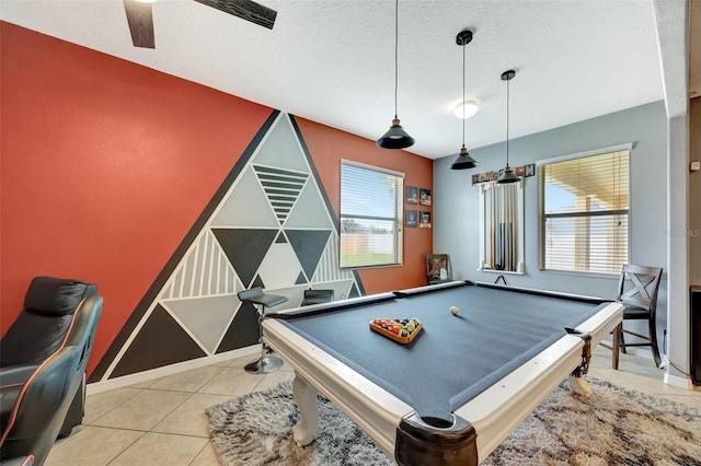 rec room with a textured ceiling, billiards, light tile patterned floors, and ceiling fan