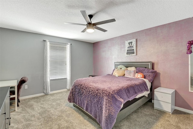 bedroom featuring light carpet, a textured ceiling, and ceiling fan