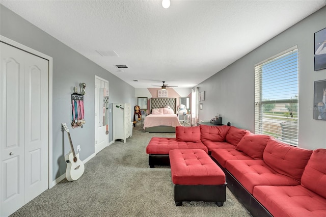 living room featuring a textured ceiling, carpet flooring, and ceiling fan