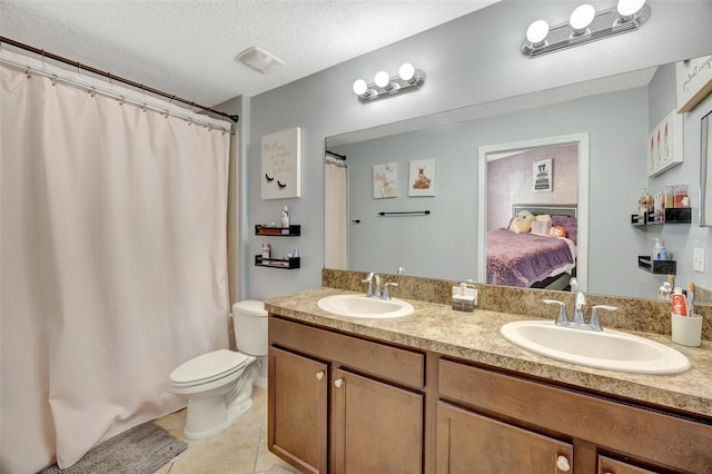 bathroom featuring tile patterned floors, vanity, toilet, and a textured ceiling