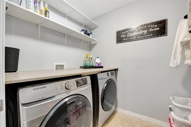 washroom with washing machine and clothes dryer and light tile patterned flooring