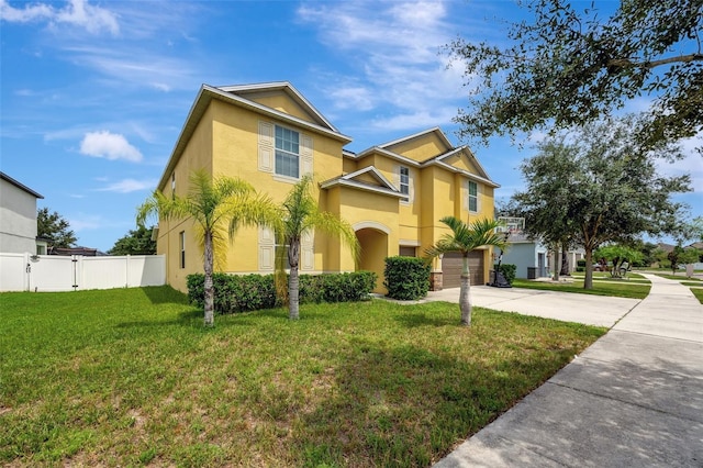 10820 Carloway Hills Dr, Wimauma, FL 33598 - view of front facade with fence, driveway, an attached garage, stucco siding, and a front lawn