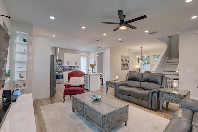 2860 14th Ave N, Saint Petersburg, FL 33713 - living area featuring stairway, light wood-style flooring, ceiling fan with notable chandelier, visible vents, and recessed lighting