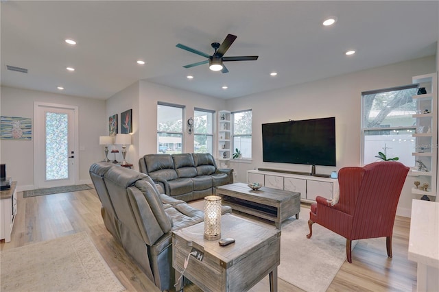 living room featuring light hardwood / wood-style flooring and ceiling fan