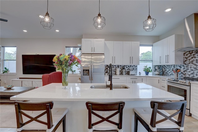 2860 14th Ave N, Saint Petersburg, FL 33713 - kitchen featuring decorative backsplash, stainless steel appliances, wall chimney exhaust hood, a sink, and a breakfast bar area