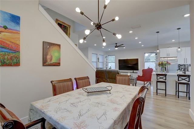 2860 14th Ave N, Saint Petersburg, FL 33713 - dining area featuring ceiling fan with notable chandelier, light wood finished floors, and recessed lighting