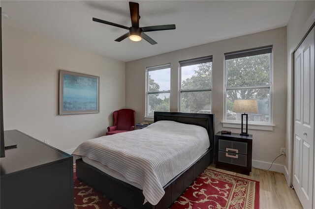 bedroom featuring light wood-type flooring, ceiling fan, and a closet