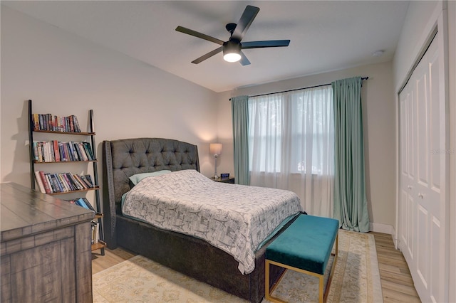 bedroom featuring light hardwood / wood-style flooring, ceiling fan, and a closet