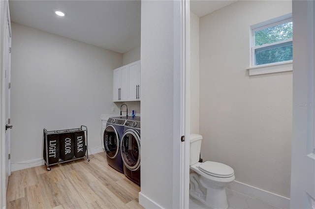 laundry area with light wood-type flooring and washing machine and clothes dryer