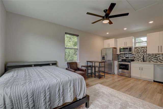 2860 14th Ave N, Saint Petersburg, FL 33713 - bedroom with stainless steel fridge, a sink, multiple windows, and light wood finished floors