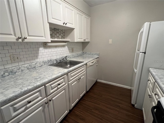 kitchen featuring decorative backsplash, white appliances, dark wood-type flooring, white cabinetry, and a sink