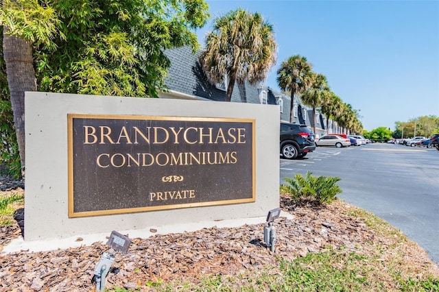 community / neighborhood sign featuring uncovered parking