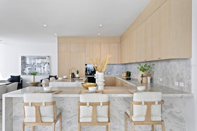 kitchen with light brown cabinetry and a kitchen bar